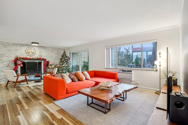 living room with light wood finished floors, baseboards, brick wall, crown molding, and a fireplace