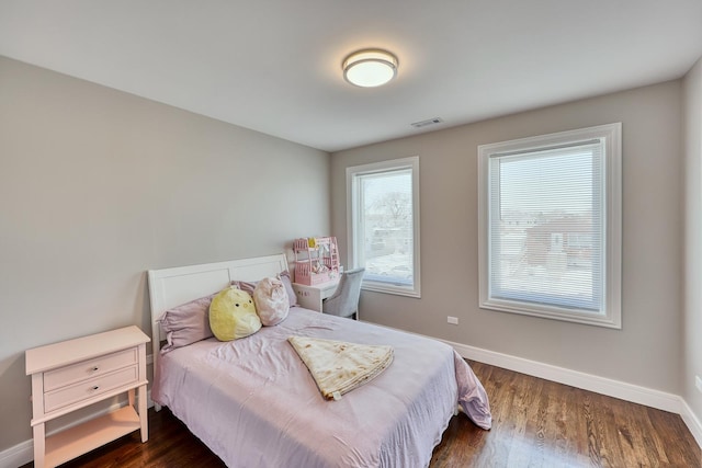 bedroom featuring dark wood finished floors, visible vents, and baseboards