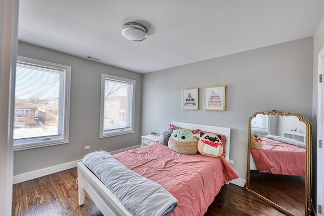 bedroom with visible vents, baseboards, and dark wood-type flooring