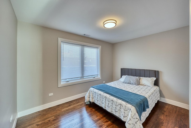 bedroom featuring dark wood-style floors, visible vents, and baseboards