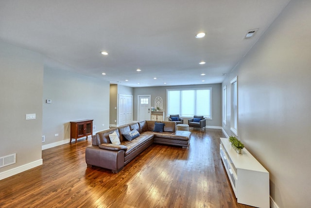 living room featuring dark wood-type flooring, recessed lighting, and visible vents