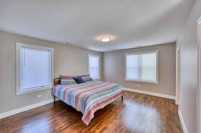 bedroom featuring dark wood-style floors, visible vents, and baseboards