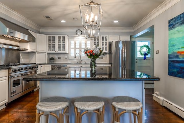 kitchen with glass insert cabinets, white cabinets, a kitchen island, and appliances with stainless steel finishes