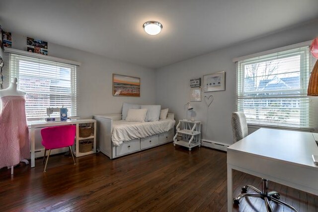 bedroom featuring multiple windows, baseboard heating, and dark wood-type flooring