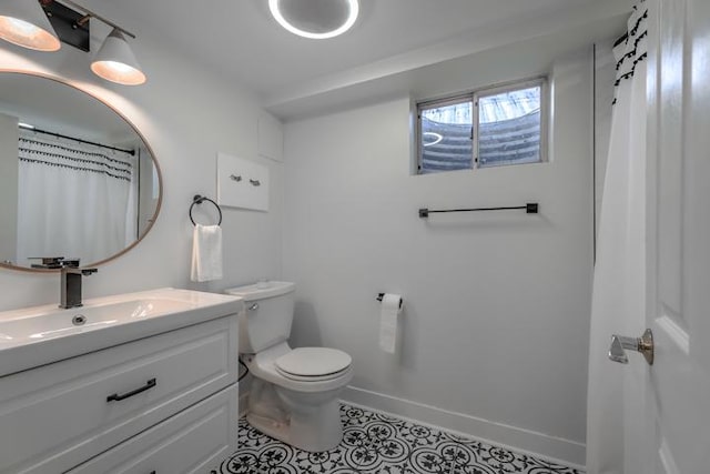 full bathroom featuring toilet, vanity, a shower with curtain, baseboards, and tile patterned floors