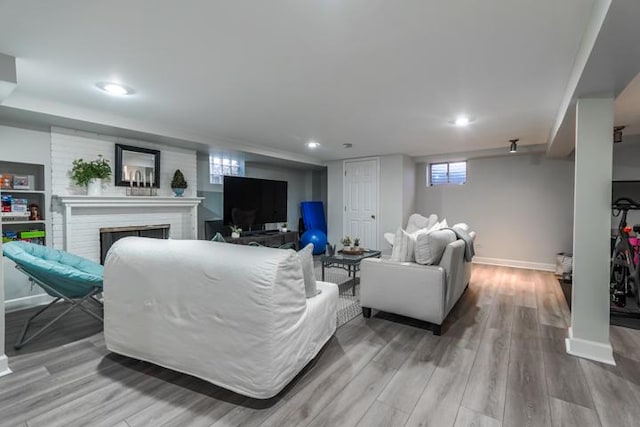 living area featuring recessed lighting, a fireplace, baseboards, and wood finished floors