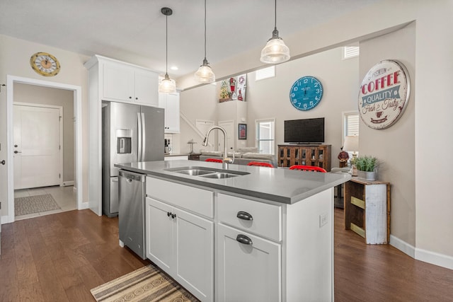 kitchen featuring dishwasher, an island with sink, hanging light fixtures, white cabinetry, and a sink