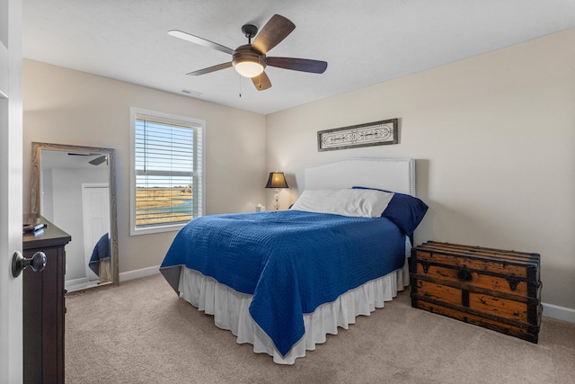 bedroom featuring a ceiling fan, light colored carpet, visible vents, and baseboards