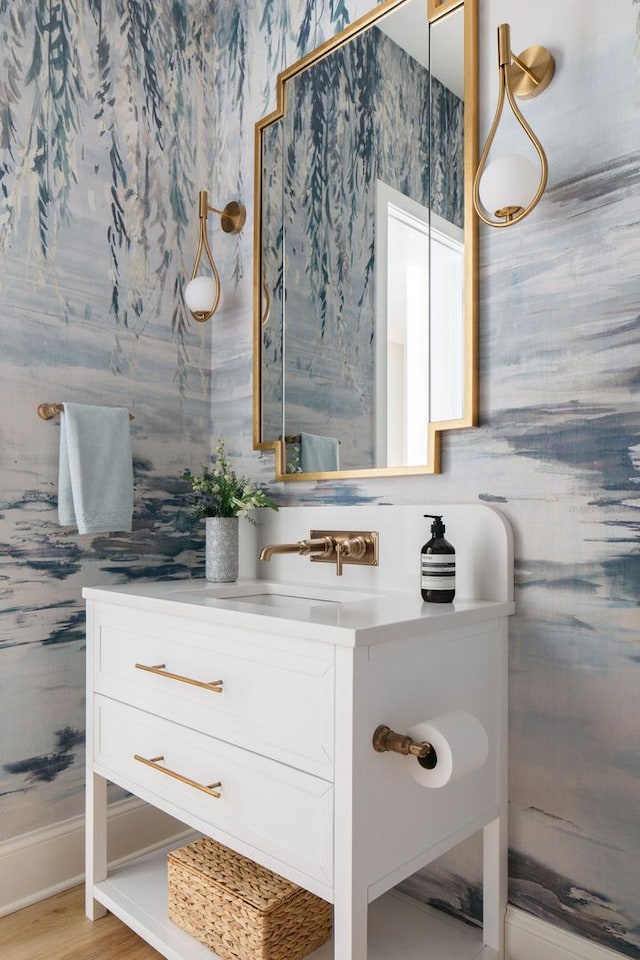 bathroom with wallpapered walls and vanity