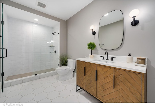 bathroom with toilet, vanity, a shower stall, and visible vents