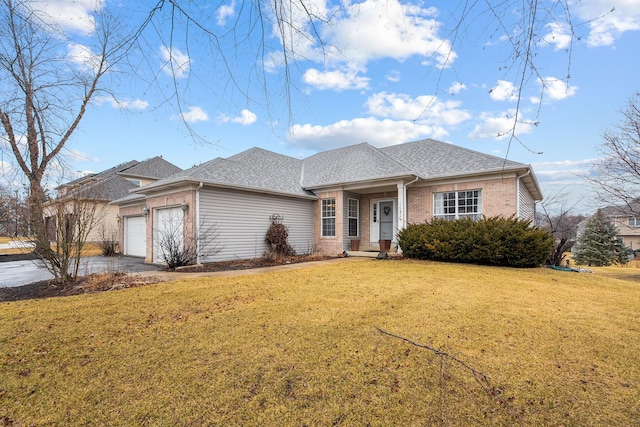 view of front of house with brick siding, roof with shingles, an attached garage, driveway, and a front lawn