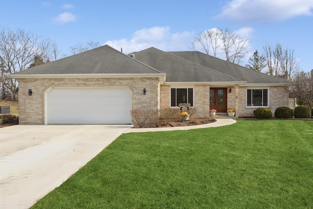 single story home featuring a garage, driveway, brick siding, and a front yard