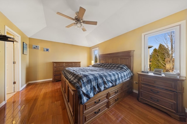 bedroom with lofted ceiling, wood-type flooring, and baseboards