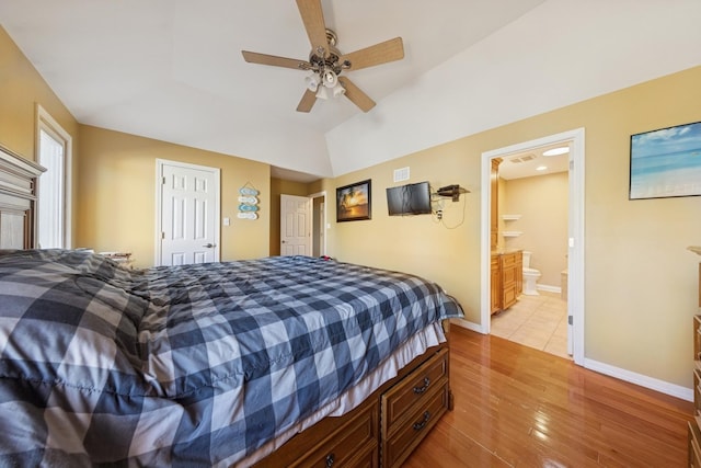 bedroom featuring connected bathroom, vaulted ceiling, ceiling fan, light wood-type flooring, and baseboards