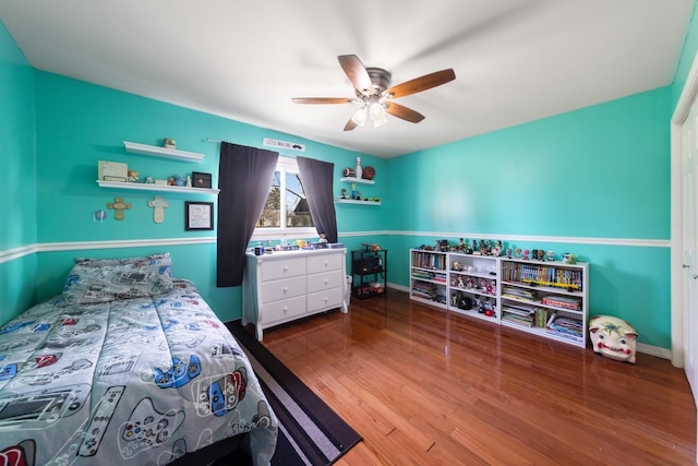 bedroom with ceiling fan, baseboards, and wood finished floors