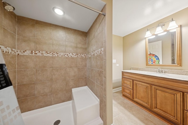 bathroom featuring tiled shower, tile patterned flooring, and vanity