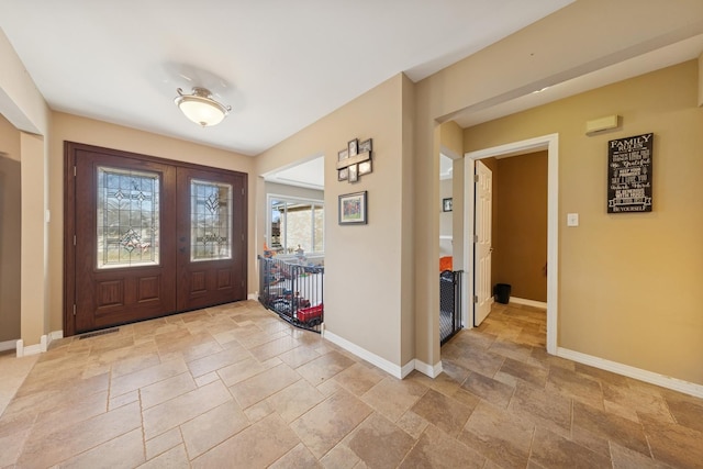 foyer entrance featuring stone finish flooring and baseboards