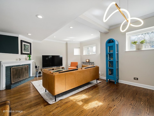 living area featuring recessed lighting, a fireplace, wood finished floors, baseboards, and crown molding