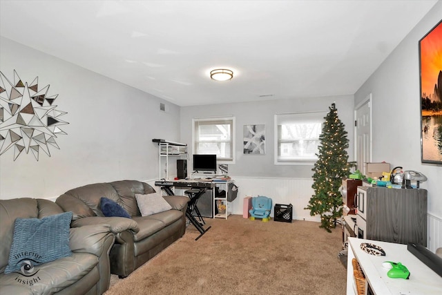 living area with visible vents, carpet flooring, and wainscoting