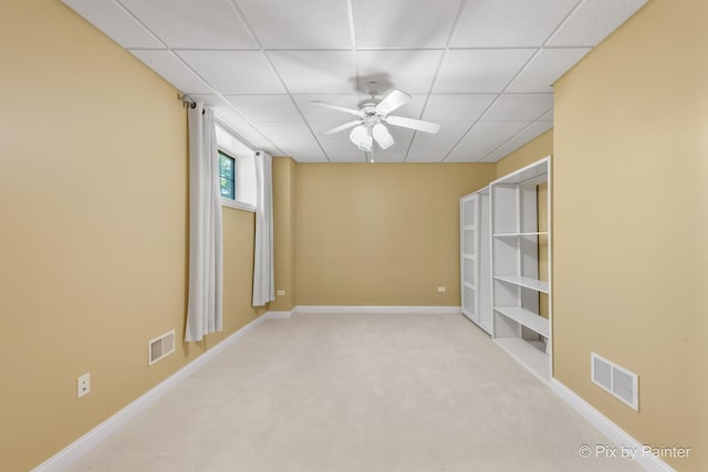 spare room featuring light carpet, visible vents, and a paneled ceiling