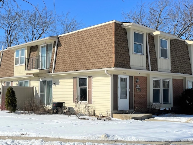 townhome / multi-family property featuring mansard roof and a shingled roof