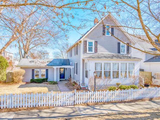 view of front of house featuring a fenced front yard and a chimney