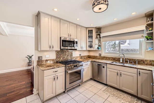 kitchen with recessed lighting, stainless steel appliances, a sink, dark stone counters, and open shelves