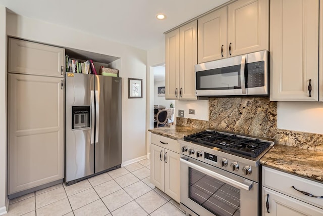 kitchen with recessed lighting, decorative backsplash, appliances with stainless steel finishes, light tile patterned flooring, and dark stone counters