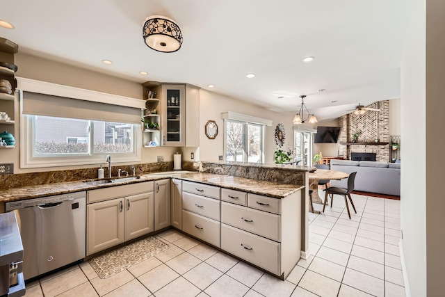 kitchen featuring a peninsula, a sink, a fireplace, open shelves, and stainless steel dishwasher