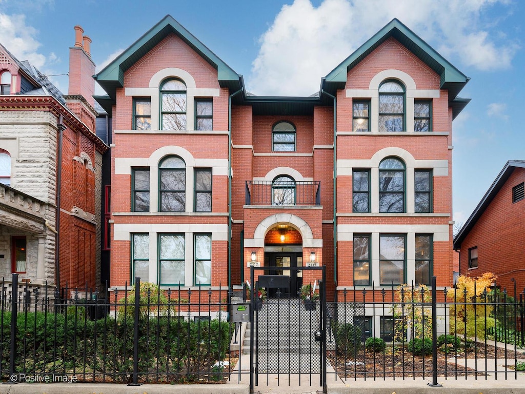 view of front of house featuring brick siding and a fenced front yard