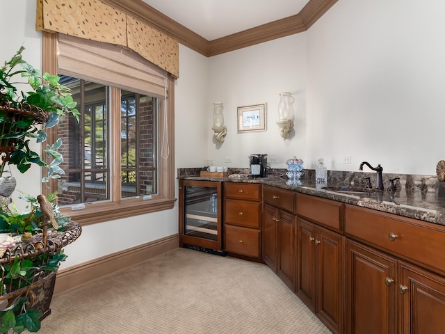 interior space with wine cooler, a sink, baseboards, double vanity, and crown molding