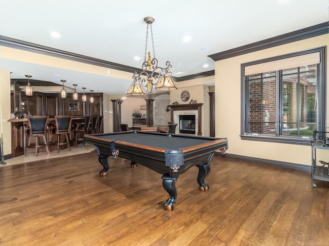 game room featuring a fireplace, a dry bar, light wood-style floors, ornamental molding, and baseboards