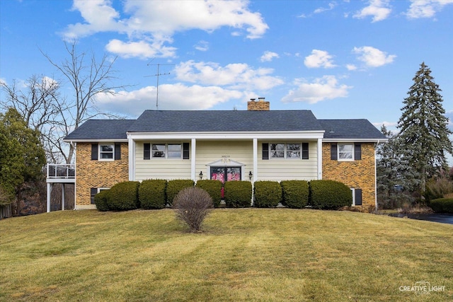 split foyer home with a front yard, brick siding, and a chimney