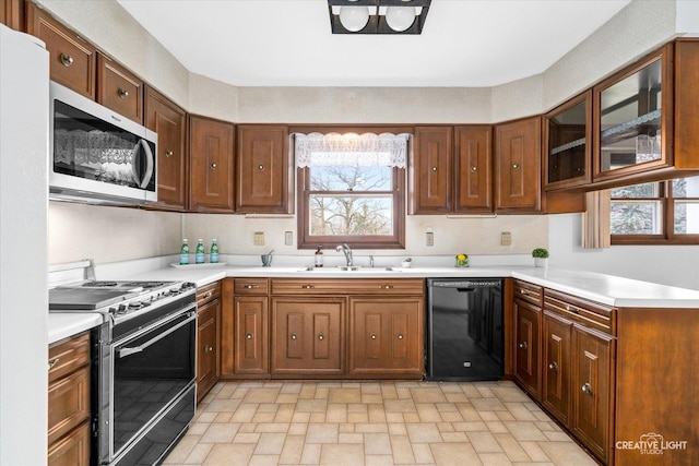 kitchen with stainless steel microwave, range, dishwasher, and light countertops