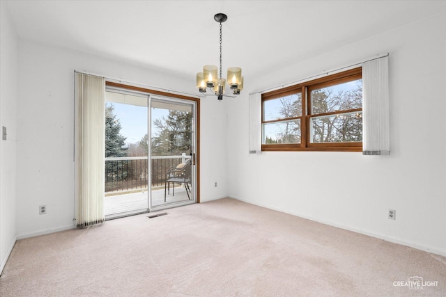 unfurnished room featuring baseboards, carpet, visible vents, and an inviting chandelier