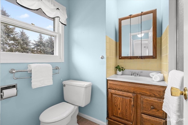 bathroom featuring toilet, vanity, and baseboards