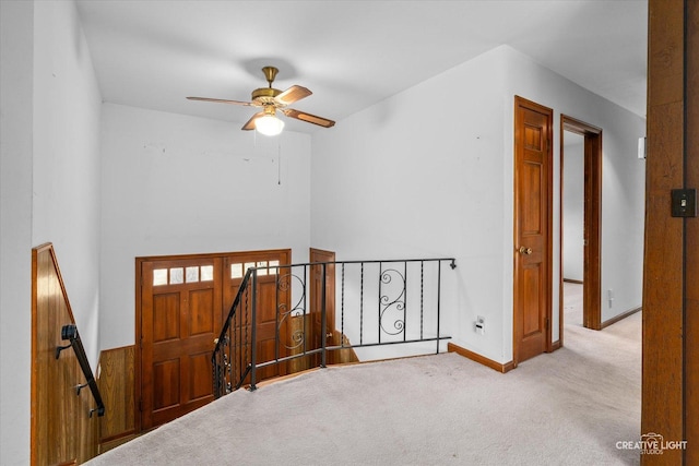 corridor with baseboards, light carpet, and an upstairs landing