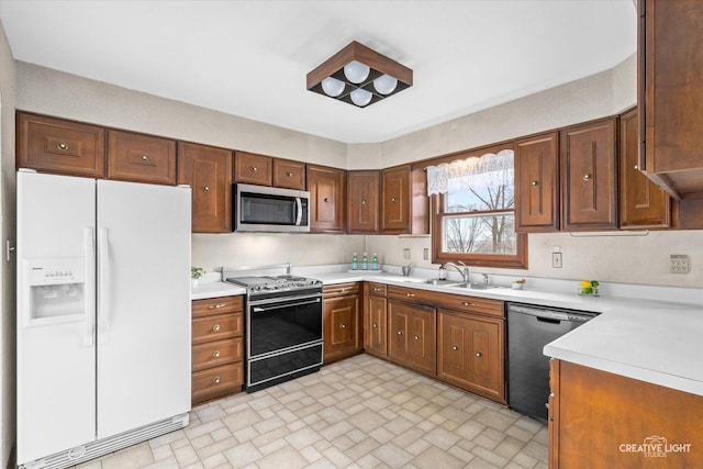 kitchen with white refrigerator with ice dispenser, a sink, range, dishwasher, and stainless steel microwave