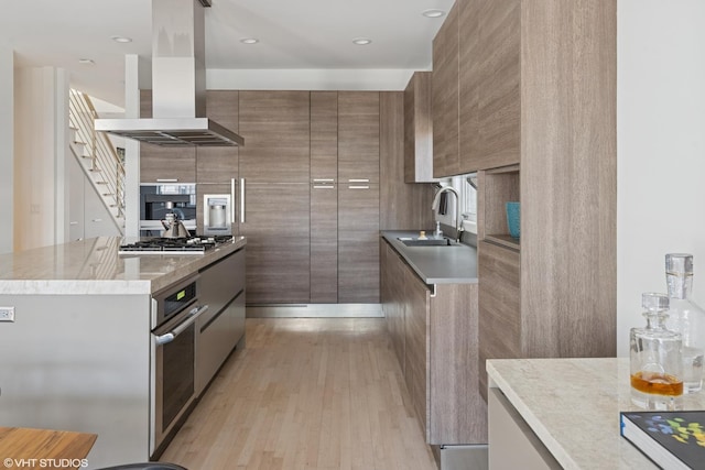 kitchen with a sink, appliances with stainless steel finishes, modern cabinets, and island exhaust hood