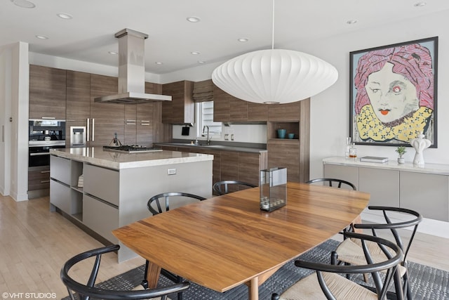 dining space featuring recessed lighting and light wood-style flooring