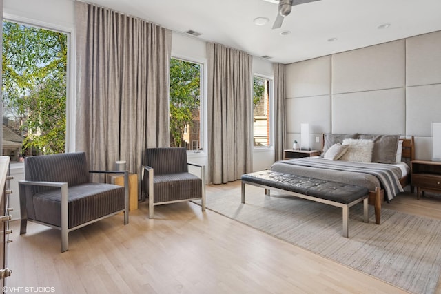 bedroom with light wood-style floors and visible vents