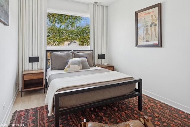 bedroom with wood finished floors and baseboards