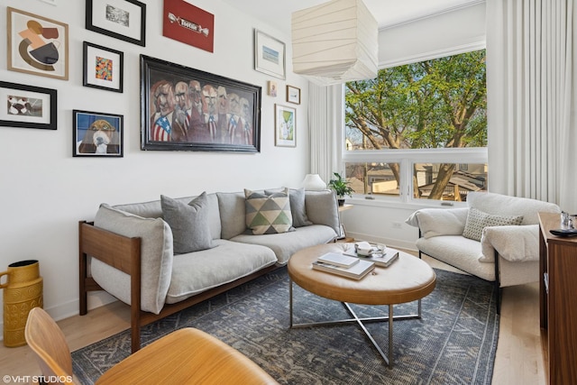 living room with dark wood-type flooring, plenty of natural light, and baseboards