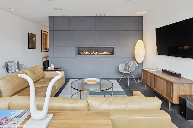 living area with a fireplace, visible vents, and tile patterned floors