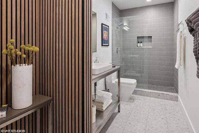 bathroom with visible vents, a sink, a tile shower, and toilet