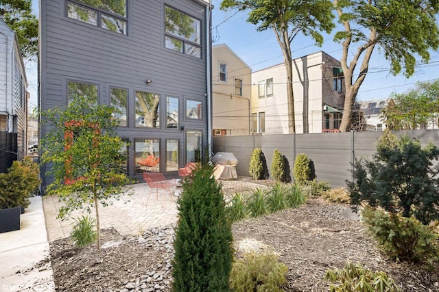 back of property featuring a patio area and fence