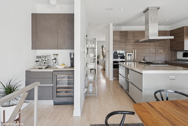 kitchen featuring beverage cooler, island range hood, decorative backsplash, modern cabinets, and stainless steel appliances