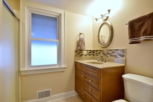 bathroom with toilet, vanity, visible vents, tile patterned floors, and tasteful backsplash