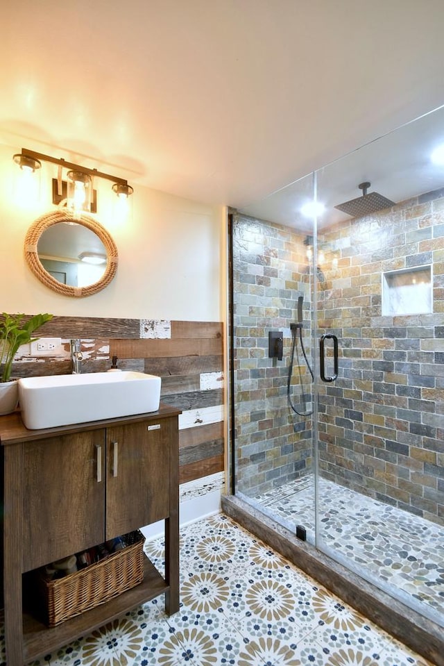 bathroom with tile patterned flooring, wainscoting, a shower stall, and vanity