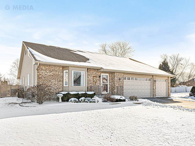 ranch-style home featuring brick siding, an attached garage, and fence